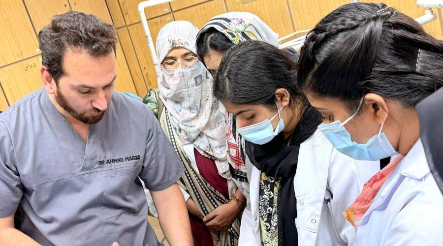 Dental students practicing clinical photography techniques in orthodontics training session in Lahore